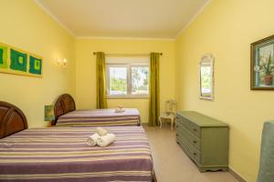 アルマカオ・デ・ペラにあるCasa Brancaの黄色い壁のベッドルーム1室(ベッド2台付)