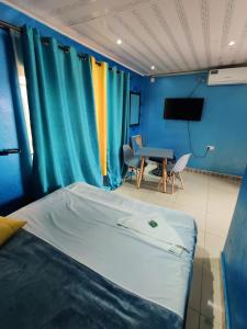 1 dormitorio con 1 cama y 1 mesa con sillas en Bukari Executive Lodge, en Mpongwe
