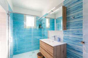 ein blaues Badezimmer mit einem Waschbecken und einem Spiegel in der Unterkunft Midori-an 緑庵 - The Garden in Maglie