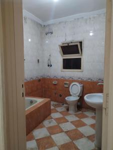 a bathroom with a tub and a toilet and a sink at USERSEEF in Cairo
