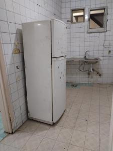 a white refrigerator in a kitchen with a sink at USERSEEF in Cairo
