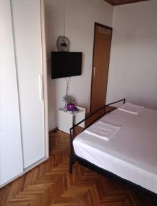 ein Schlafzimmer mit einem Bett und einem TV an der Wand in der Unterkunft Apartments Lorio in Vodice