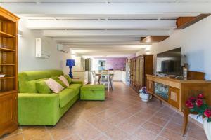 ein Wohnzimmer mit einem grünen Sofa und einer Küche in der Unterkunft Midori-an 緑庵 - The Garden in Maglie