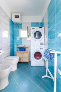 a blue bathroom with a washing machine and a toilet at Midori-an 緑庵 - The Garden in Maglie