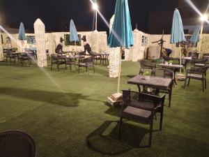 a group of tables and chairs with umbrellas at night at USERSEEF in Cairo