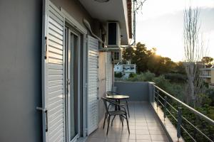 a small balcony with a table and chairs on it at Enjoy A&A in Skala Oropou