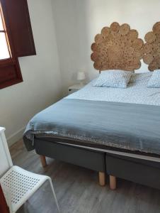 a bed with a wooden headboard in a bedroom at Casa el Hoyo in Hermigua