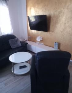ein Wohnzimmer mit einem Sofa, einem Tisch und einem TV in der Unterkunft Apartments Lorio in Vodice