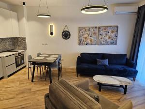 a living room with a blue couch and a table at Klaudia Apartments in Himare +79 photos