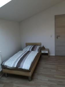 een slaapkamer met een bed en een houten vloer bij Ferienhaus-Seedo in Herleshausen