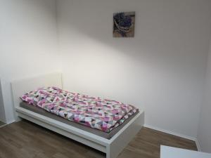 een bed in een witte kamer met een deken erop bij Ferienhaus-Seedo in Herleshausen