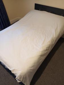 a bed with white sheets on top of it at 29 ansell road sw17 in London
