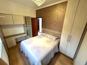 1 dormitorio con 1 cama blanca en una habitación en Apartamento inteiro muito aconchegante en Joinville