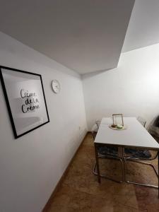 ein weißes Zimmer mit einem Tisch und einer Uhr an der Wand in der Unterkunft Apartamento funcional Arrixaca in El Palmar