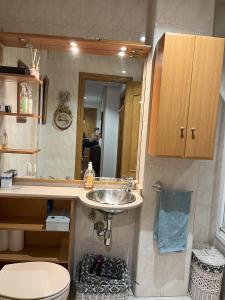W łazience znajduje się umywalka, toaleta i lustro. w obiekcie MYM Vivienda Ávila, buena situación. VUT-AV-00805 w mieście Avila