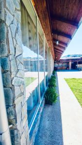 a stone building with a stone wall and windows at LA GRADINA in Coteşti