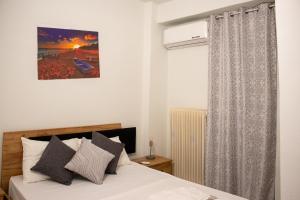 a bedroom with a bed and a window at Enjoy A&A in Skala Oropou