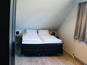 a bed with two pillows on it in a room at Prachtige vakantievilla aan IJsselmeer Makkum in Makkum