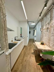 una cucina con mobili bianchi e un tavolo di legno di Apartamentos Carolina by gaiarooms a León Altre 16 foto