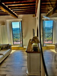 een woonkamer met een bank en grote ramen bij Casa di Nonno Gio' - Tuscan ToBe in Santa Fiora