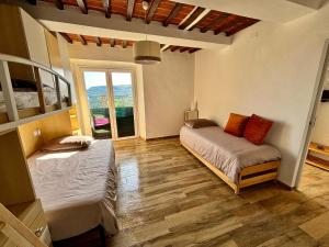 een slaapkamer met 2 bedden en een raam bij Casa di Nonno Gio' - Tuscan ToBe in Santa Fiora