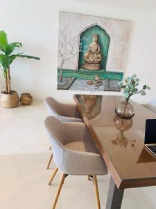 a desk with two chairs and a painting of a buddha at Extra large Luxury property with Spa, 3 min to Marbella city center in Málaga