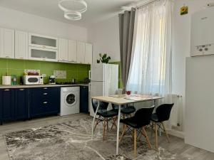 Una cocina con mesa y sillas y un refrigerador. en Ely`s Place, en Sibiu