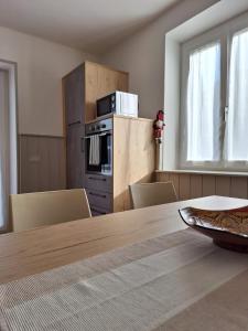 a kitchen with a table with chairs and a microwave at Appartamento Lido in Levico Terme