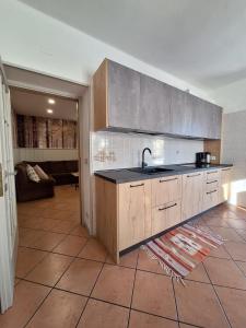 a kitchen with a sink and a living room at Appartamento Lido in Levico Terme