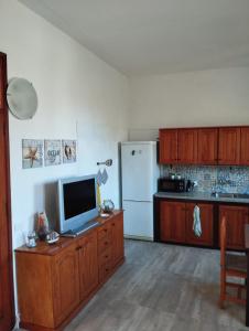 a kitchen with a television and a refrigerator at Casa el Hoyo in Hermigua