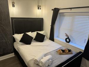 1 cama con bandeja de toallas y ventana en Impeccable 3-Bed House in Walsall en Walsall