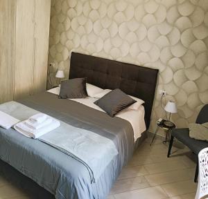 1 dormitorio con 1 cama grande y pared en Ruggiero's Rooms, en Nápoles