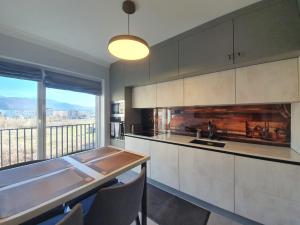 a kitchen with a table and a large window at Tzuba Luxury Home Coresi Mall Brasov in Braşov