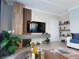 a living room with a tv and a blue couch at Tzuba Luxury Home Coresi Mall Brasov in Braşov