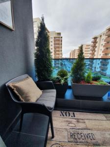 a couch sitting on a balcony with potted plants at Tzuba Luxury Home Coresi Mall Brasov in Braşov