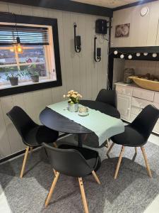 a dining room with a table and chairs in a kitchen at Koselig låve in Ålesund