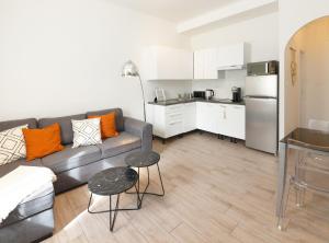 a living room with a couch and a kitchen at Luciana Cannes avec parking - proximité centre croisette -gare -plage in Cannes