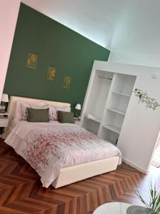 a bedroom with a large bed and a green wall at Afrodite Suite con terrazzino in Ercolano
