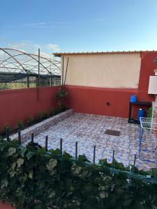 patio z czerwoną ścianą i stołem w obiekcie Afrodite Suite con terrazzino w mieście Ercolano