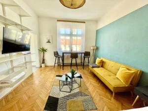 StayHere City Apartment 36 في غراتس: غرفة معيشة مع أريكة وطاولة