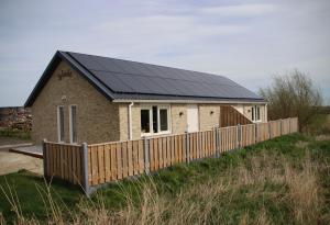 ein Haus mit Solardach auf einem Feld in der Unterkunft Vakantie appartementen Sylsicht in Sexbierum