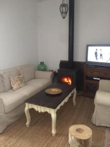 sala de estar con sofá y chimenea en Casa Rural Rafaela 