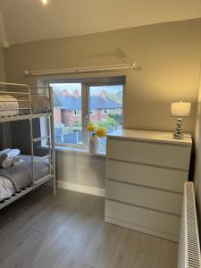 1 dormitorio con litera y ventana en Impeccable 3-Bed House in Walsall en Walsall