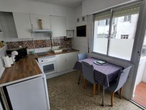 eine kleine Küche mit einem Tisch und Stühlen in der Unterkunft VUT El Muro 1 in Santiago de Compostela