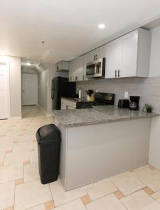 a kitchen with white cabinets and a trash can at Pleasing 4- Bed Apartment Close to NYC in Jersey City