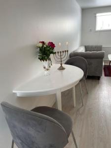 una mesa blanca con un jarrón de flores y sillas en A new apartment close to City, en Boden