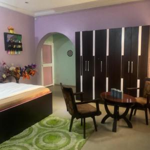 a bedroom with a bed and a table and chairs at Health Plaza Abuja in Abuja