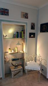 a room with a chair and a shelf with books at In Battaglino in Cascina