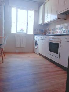 uma cozinha com uma máquina de lavar roupa e uma janela em Apartamento Sobreira en centro Allariz con WIFI em Allariz