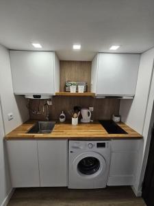 a kitchen with a sink and a washing machine at Casa da Aldeia in Olhos de Água